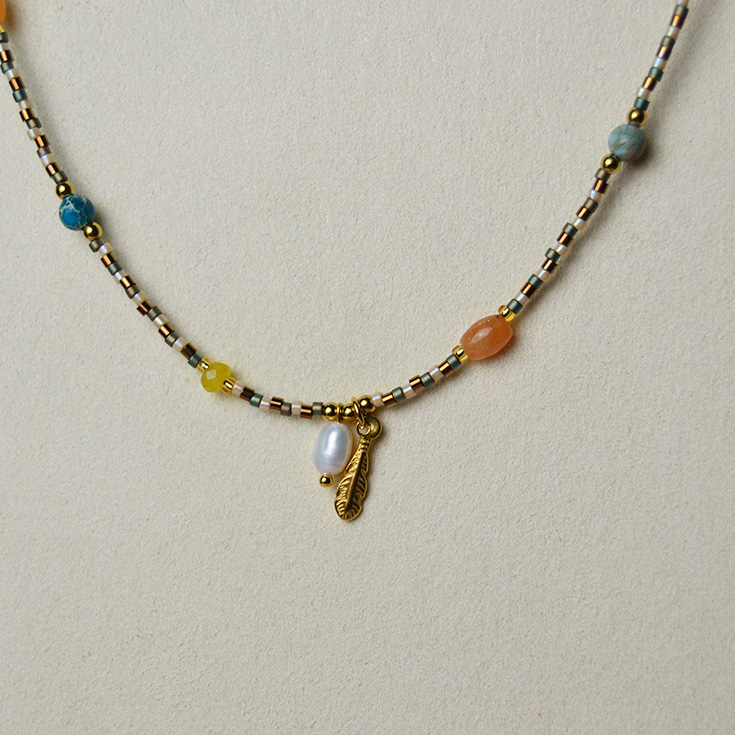 collar bolitas con pluma dorada