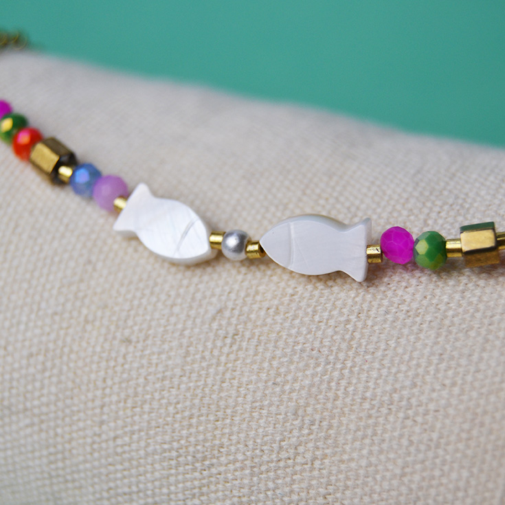 pulsera tobillera dorada con piedras de colores y peces blancos