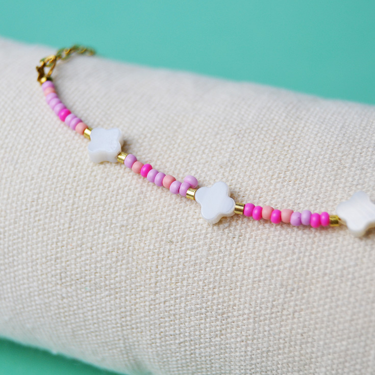 pulsera tobillera dorada con piedras de colores y flor blanca
