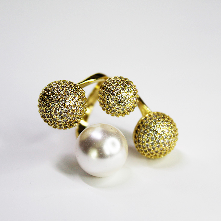 anillo dorado con esferas y perla