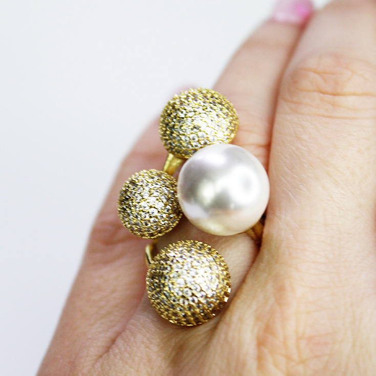 anillo dorado con esferas y perla