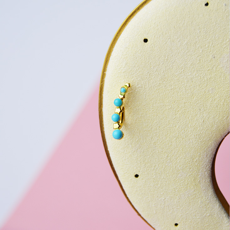 par de pendientes trepadores dorados con perlas azules