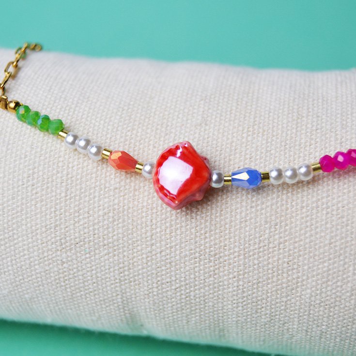 pulsera tobillera dorada con piedras de colores y concha roja